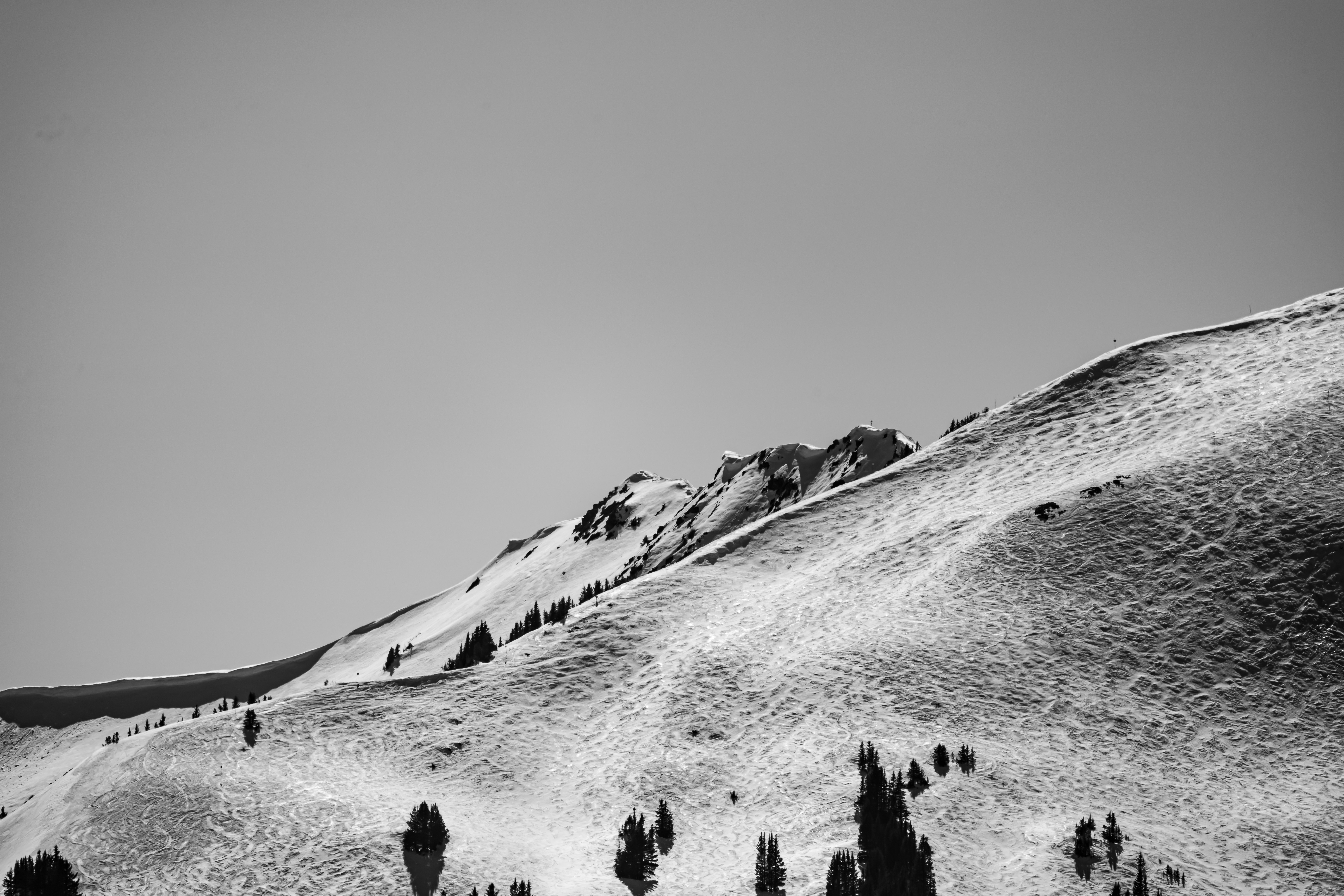 grayscale photo of people on snow covered mountain